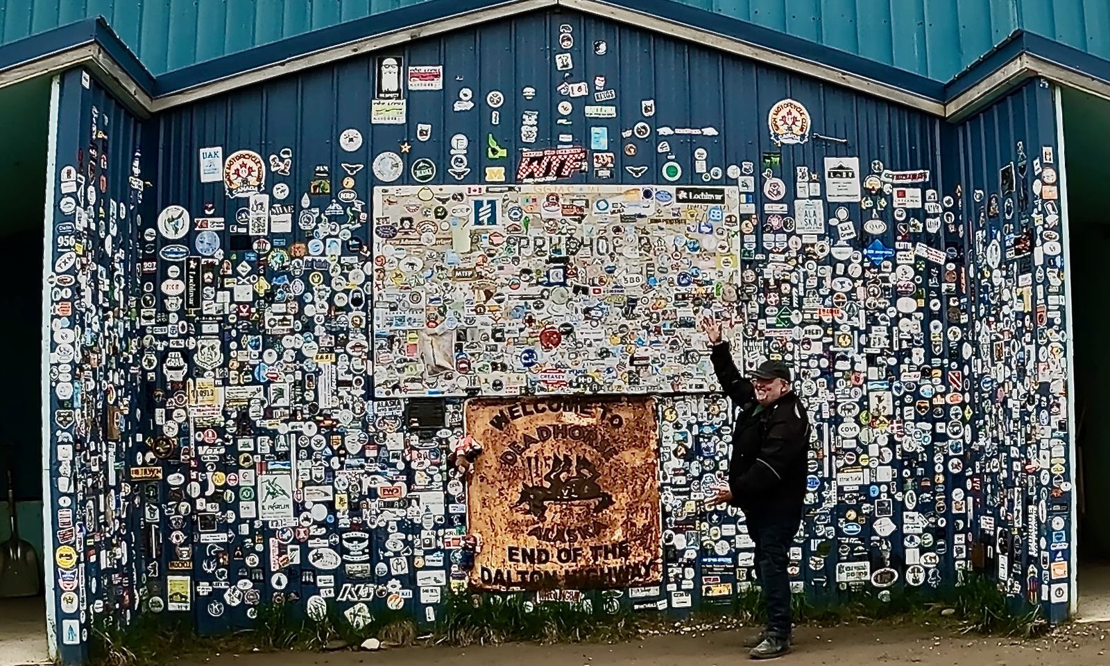 The sticker-covered wall at the end of the Dalton Highway, Deadhorse